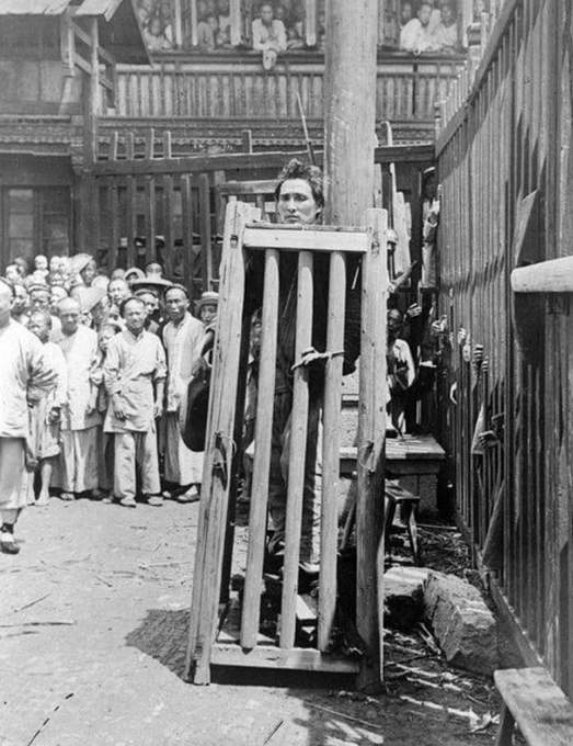 13. Um homem condenado por assassinato aprisionado em uma gaiola de madeira em uma rua na China. Ele foi deixado para morrer de sede, fome e exposição, por volta de 1930