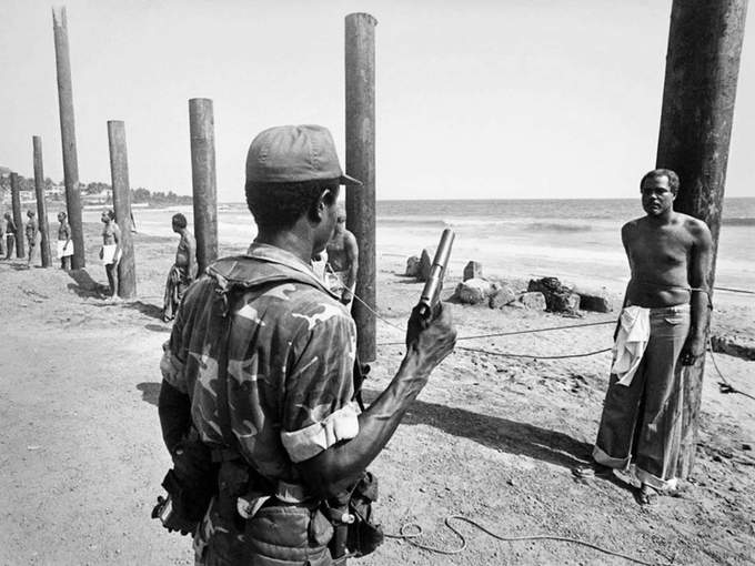 4. Um soldado do exército liberiano se prepara para executar um ex-ministro do governo após o golpe de 1980